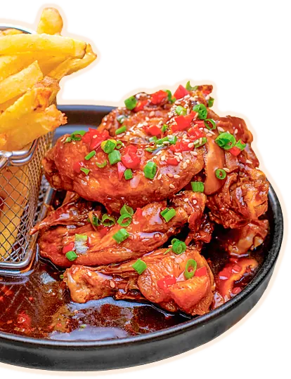 Alitas Toro bañadas en salsa con cebollita china y papas fritas
